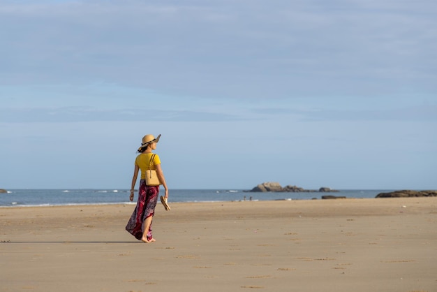 Женщина гуляет по пляжу.