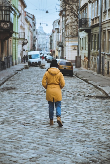 오래 된 도시 거리로 여자 산책