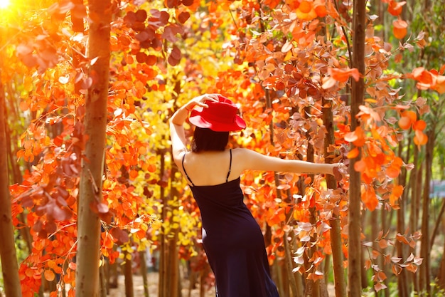 女性は夏の春に美しい色のファンタジーフラワードリームオレンジフィールドを歩きます。