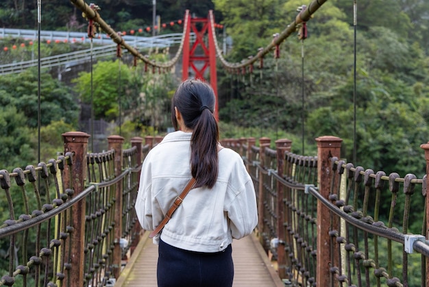 Foto donna che attraversa il ponte sospeso a wulai, taiwan