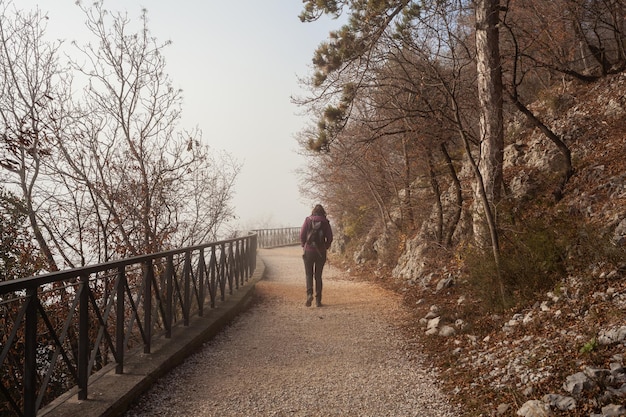 Woman walking alone on rural misty path