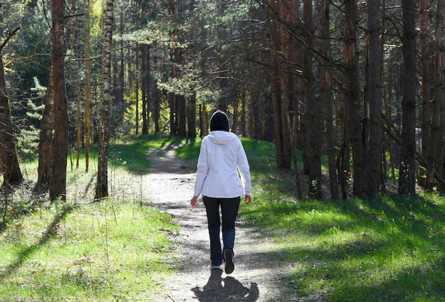 Woman walking along a path in the forest