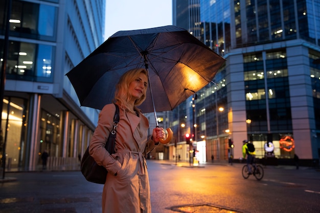 Foto donna che cammina per la città mentre piove