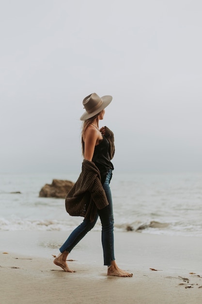 Woman walking barefoot at the beach