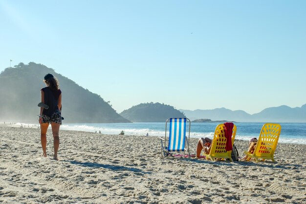 Donna che cammina sulla spiaggia di copacabana, rio de janeiro