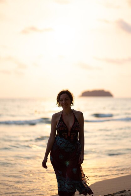 Woman walking on beach during sunset