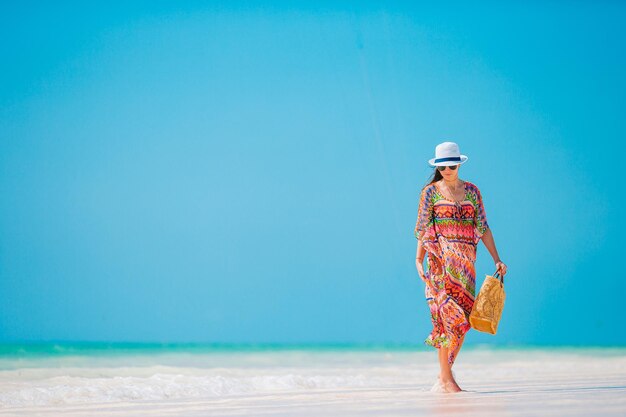 Foto donna che cammina sulla spiaggia