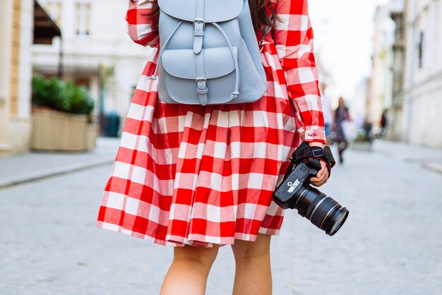 Woman walking by city with camera in her hand