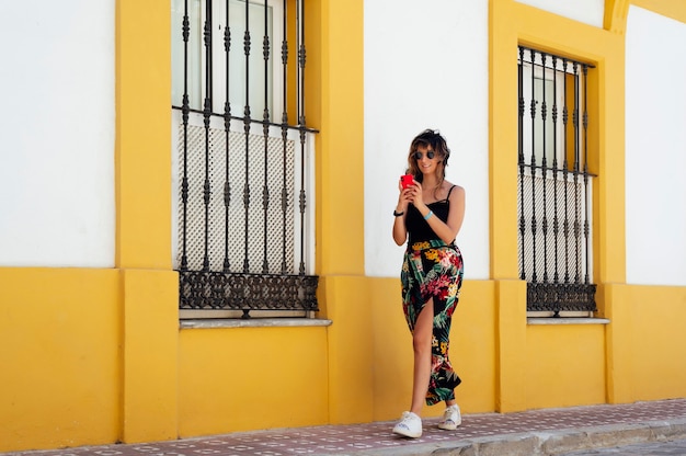 woman walking down the street while looking at the mobile phone