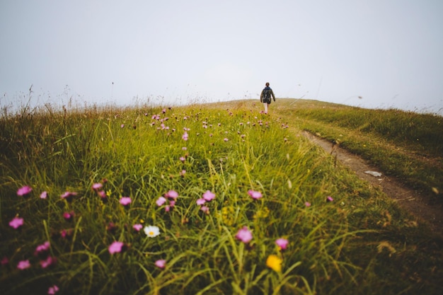 Photo woman walking on field against sky