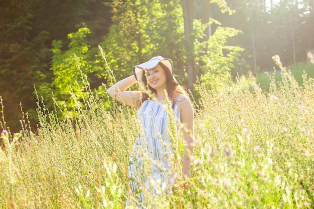 Woman walking in a field in summer sunny day