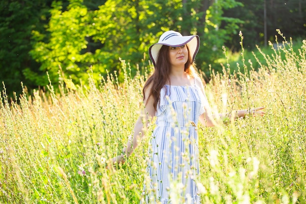 夏の晴れた日に畑を歩く女性。