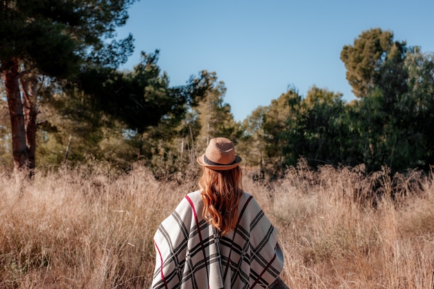 Woman walking in a field in sunset light Back to camera winter autumn life