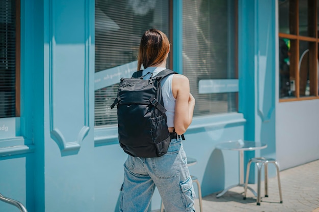 woman walking from back using backpack