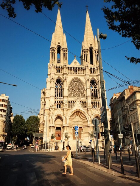 Foto donna che cammina davanti alla chiesa di saint-vincent-de-paul