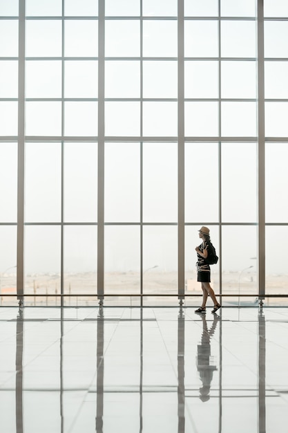 Woman walking in front of a giant glass windows