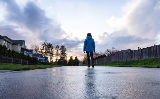 近代都市郊外の住宅街の小道を歩く女性