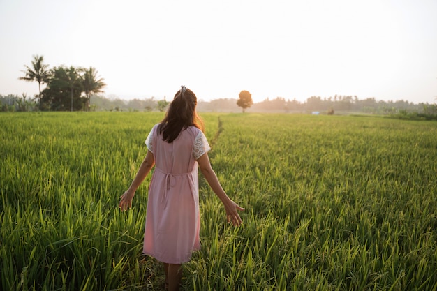 Woman walking on a rice field enjoy her time