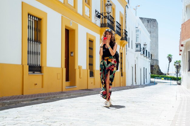 woman walking on the street looking at her smart phone