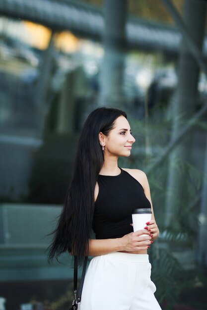 Женщина идет по улице с кофе на вынос