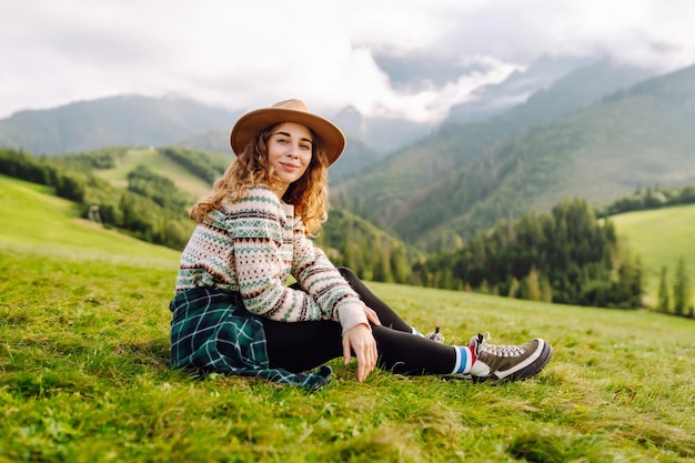 Woman walking on through green grass valley on background big mountains Resting concept