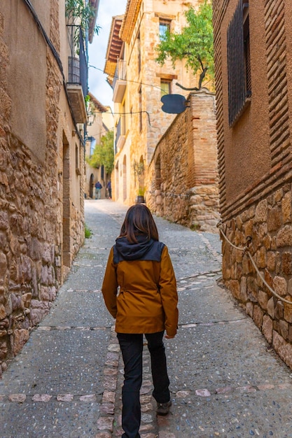 Photo a woman walking through the streets of the pyrenean village of alquezar medieval town of huesca spain