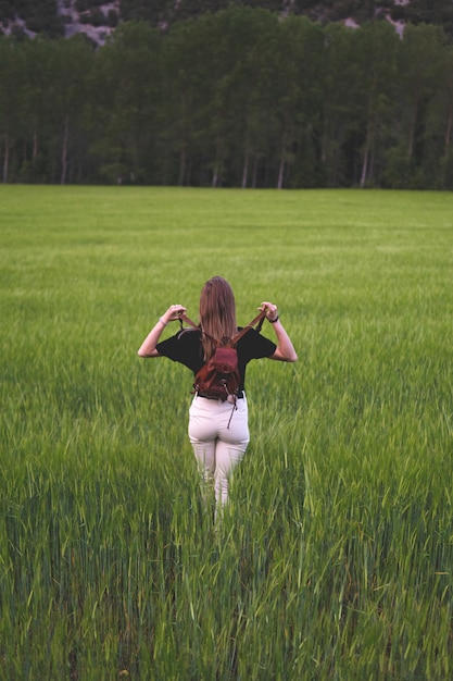 Foto donna che cammina attraverso i campi di grano