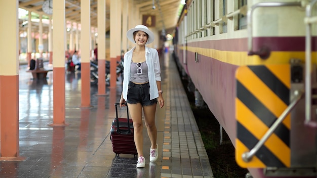 鉄道駅のプラットフォームで電車で歩いている女性