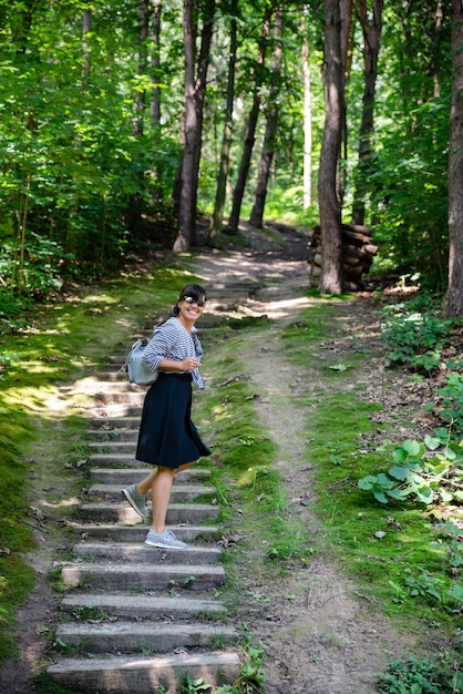 Woman walking up by old stairs in forest