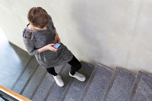 Woman walking upstairs using cell phone