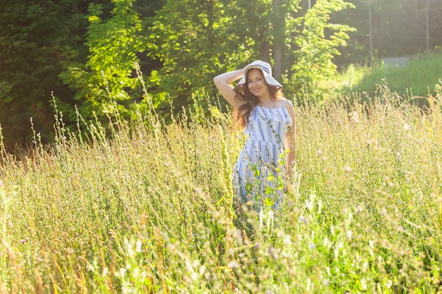 晴れた夏の日に野の花の間を歩く女性