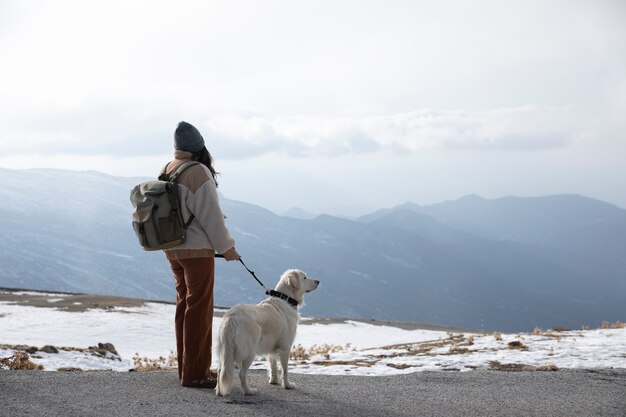 Donna che cammina con il suo labrador durante il viaggio invernale