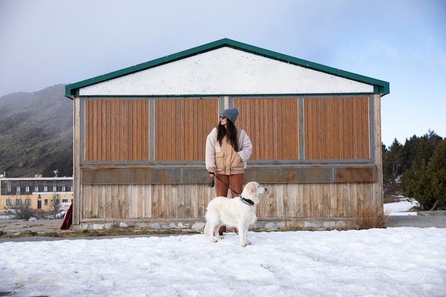 Woman walking with her labrador during winter trip