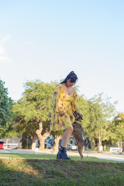 Woman walking with her pet in a public garden at sunset Pet lover