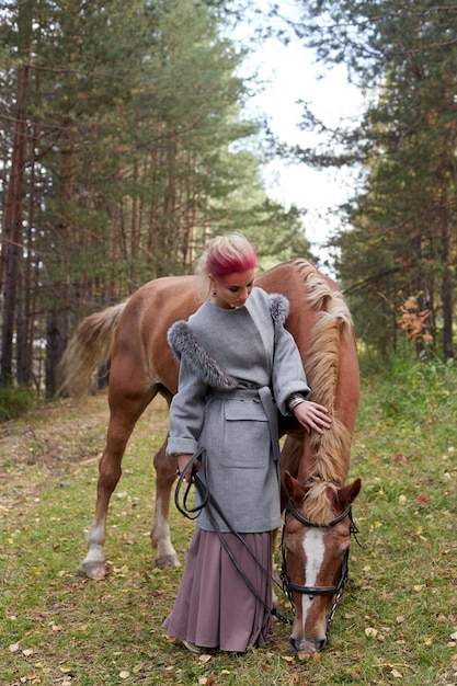 Woman walking with horse autumn on nature. 