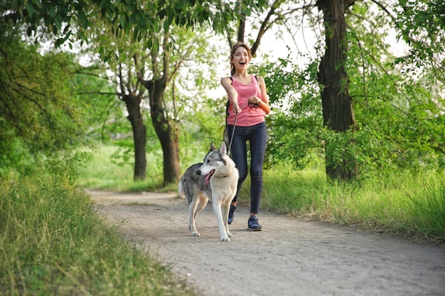 Woman walking with husky in park