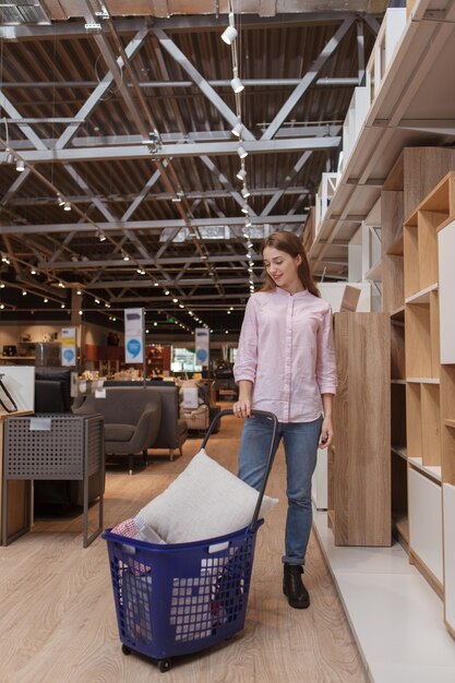 Woman walking with shopping cart at furnishings store