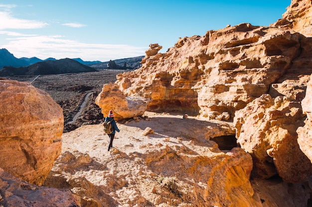 woman walking in the woods and watching rocks