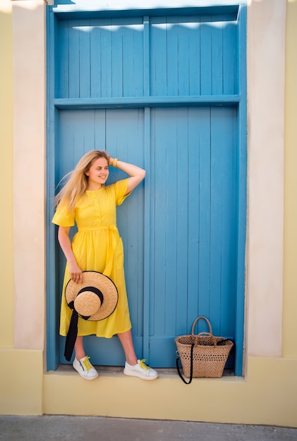 パフォス旧市街で黄色のドレスで歩く女性