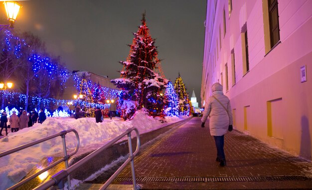 A woman walks along a Christmas decorated street