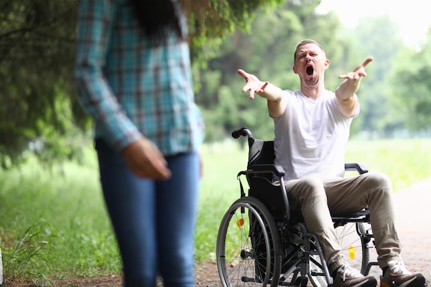 Женщина уходит разочарованная от мужчины в инвалидной коляске