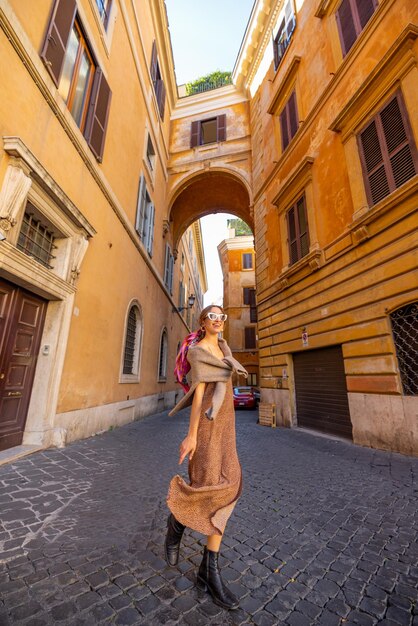 女性はローマの狭い古い通りを歩く