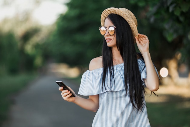 Woman walks in park and using phone.