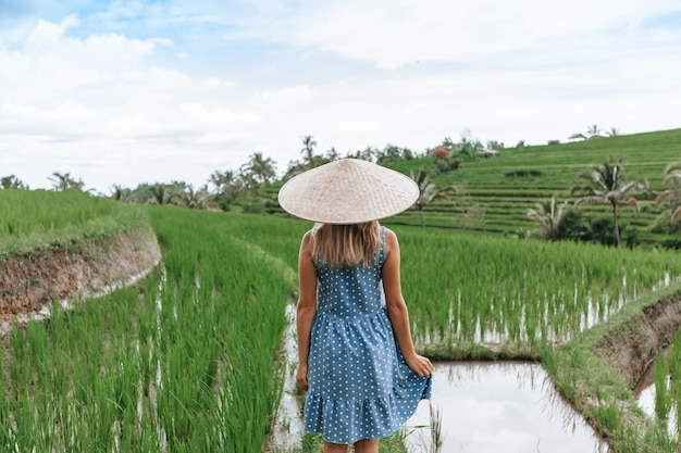 Una donna cammina sulle terrazze di riso a bali