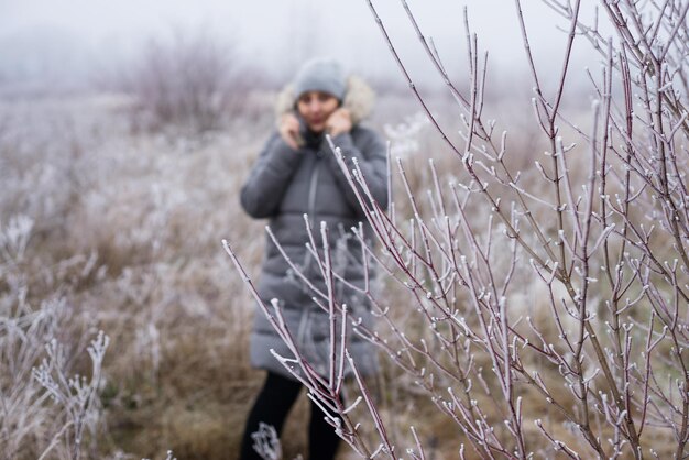 따뜻한 캐주얼 옷을 입은 한 여성이  얼음으로 인 부치 뒤에 서 있습니다.