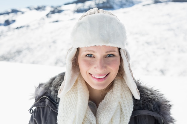 暖かい服を着た女性が雪に覆われた風景