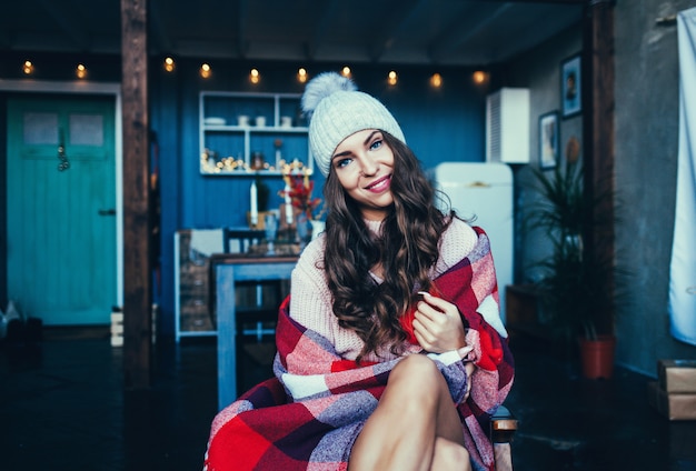 Woman in warm knitted clothes at home