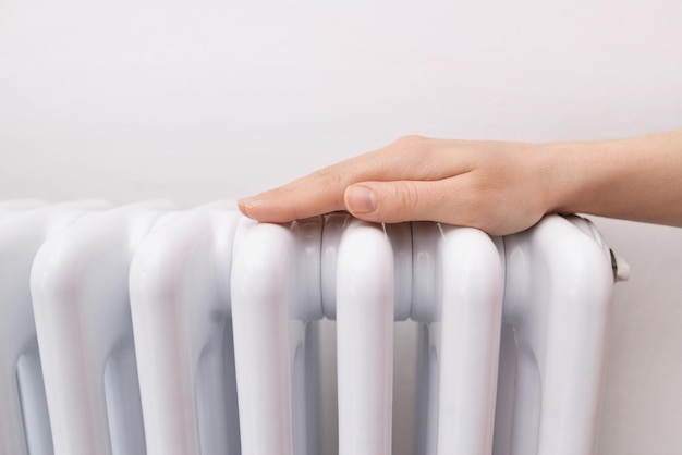 Photo woman warms up hands over heater concept of the need for good central heating