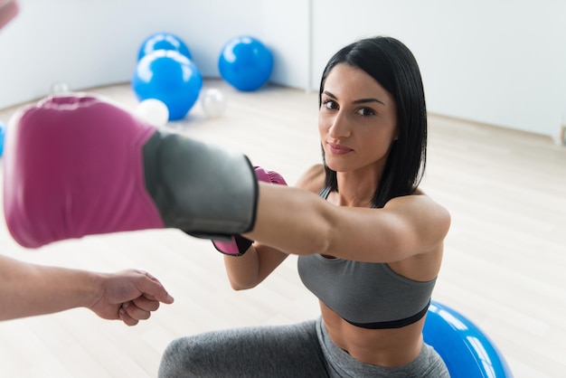 Woman Warrior With Personal Trainer In Gym