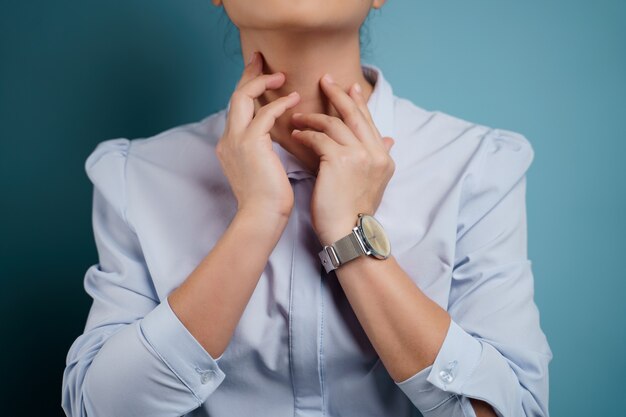 Woman was sick with sore throat isolated on blue.